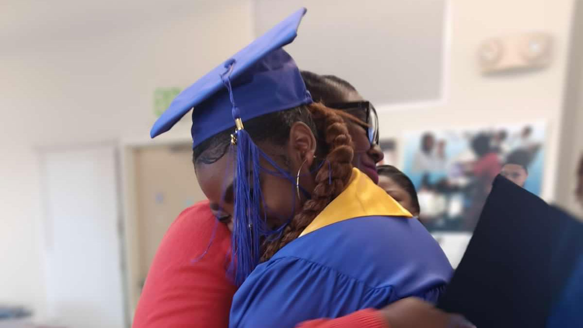 Picture of a graduating woman hugging another woman