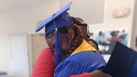 Picture of a graduating woman hugging another woman
